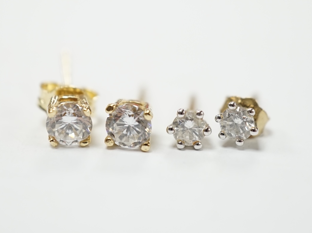 A pair of 585 and solitaire simulated diamond set ear studs and a smaller pair of 375 and solitaire diamond ear studs. Good condition.